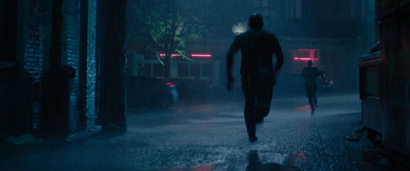 Wade chasing a man out of a rainy alley.
