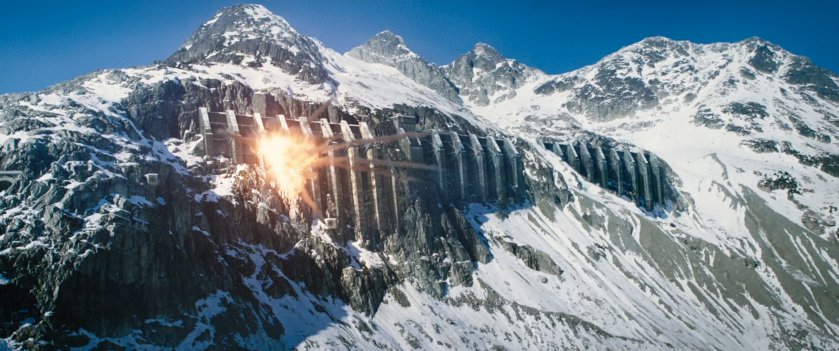 An explosion on the exterior of Ice Box Prison built into a snowy mountain side.