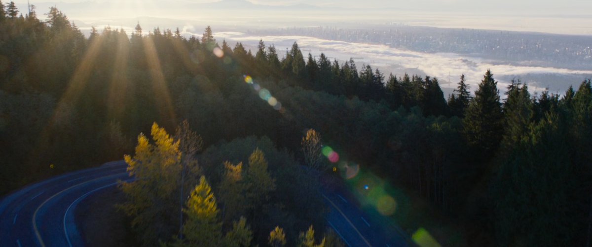 Aerial view of city above a mountain road.