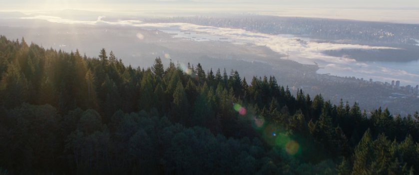 Aerial view of city above a mountain road.