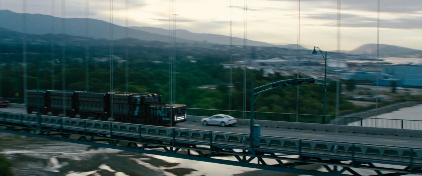 Convoy trucks crossing bridge.