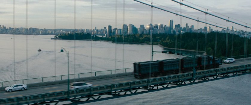 Convoy trucks crossing bridge.