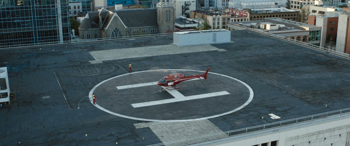 Red helicopter on roof of building.
