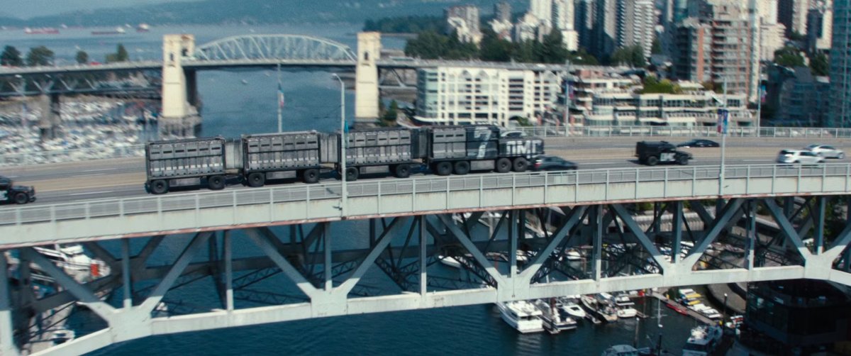 Prisoner convoy driving over city bridge.