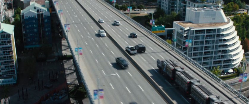 Prisoner convoy driving over city bridge.