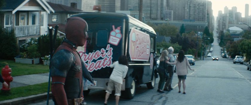 Deadpool looking down a hill towards the city.