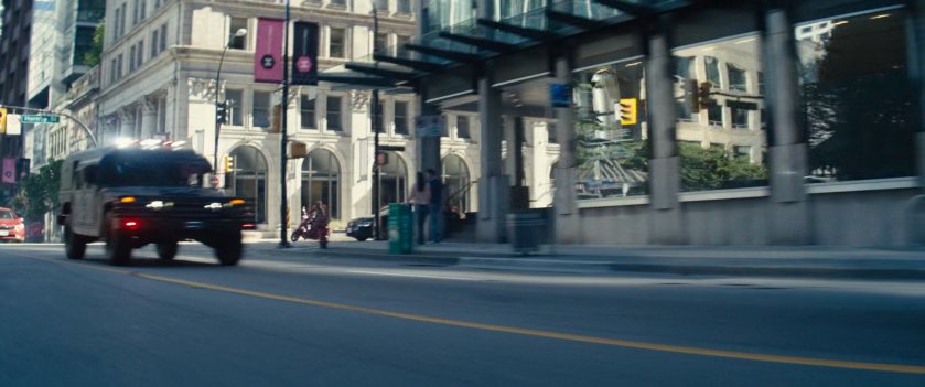 Convoy truck speeding through city street.