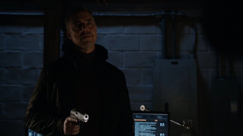 Felix Blake holding a gun in his basement.