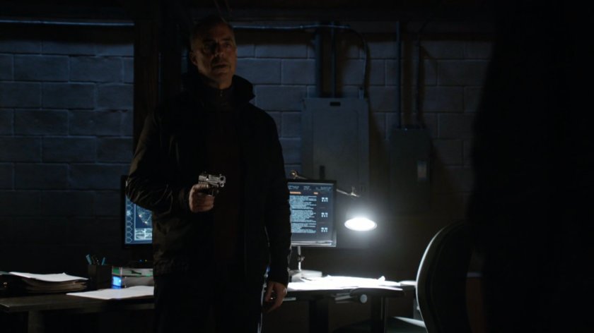 Felix Blake holding a gun in his basement.