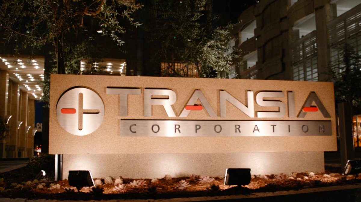 Transia Corporation sign lit up at night.