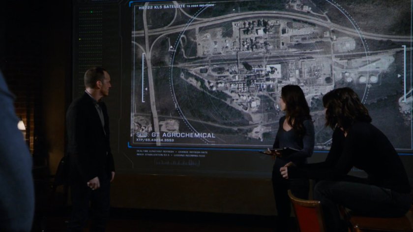 Coulson, May, and Daisy in front of a big screen showing GT AgroChemical.