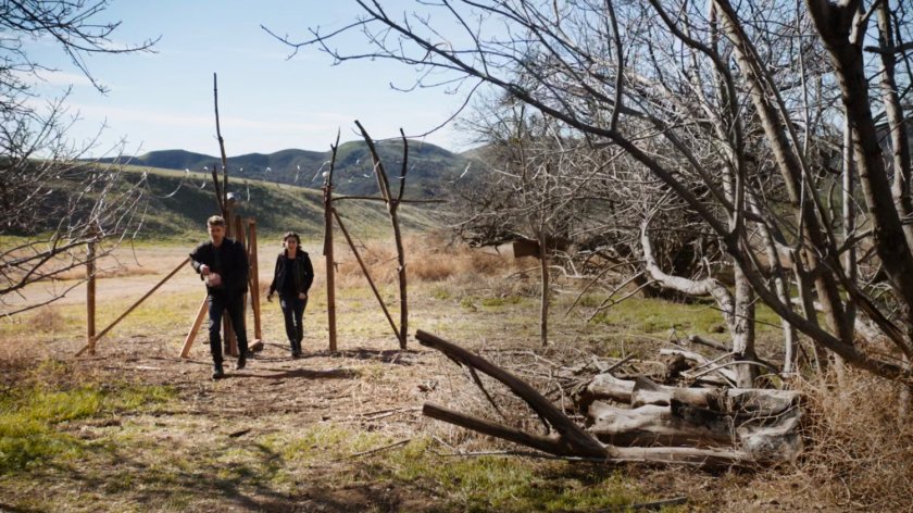 Daisy and Lincoln entering barbed wire fence in Badlands.