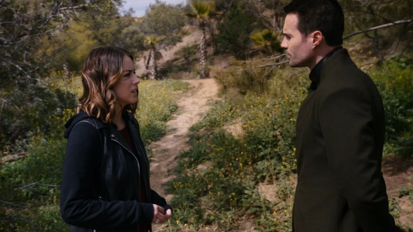 Hive and Daisy on hill with trail and foliage behind them.