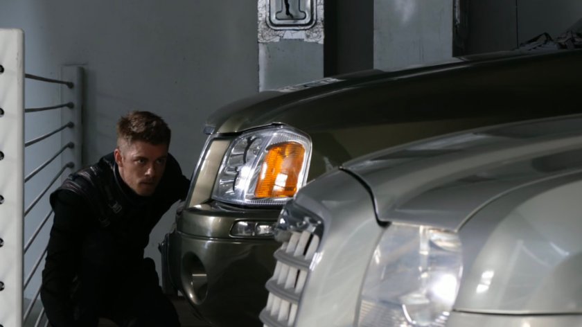 Lincoln hiding behind car in Illinois parking structure.