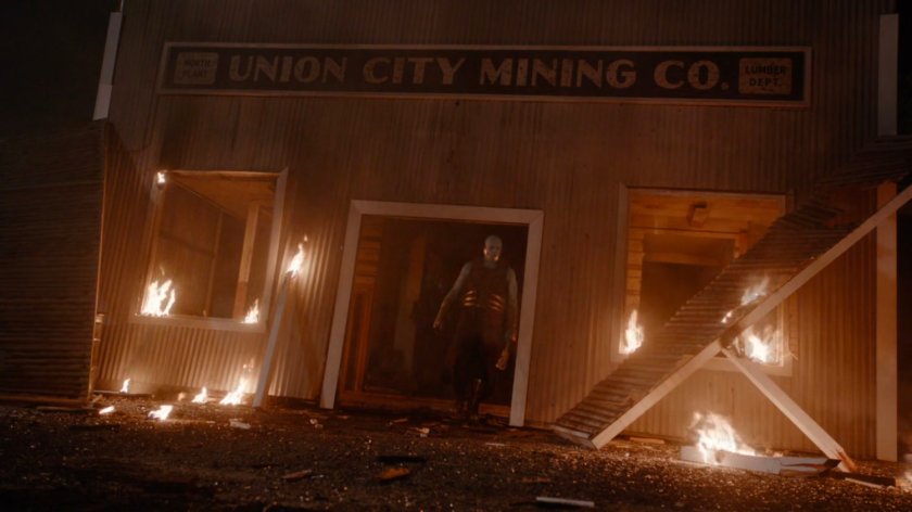 A Kree walks out of flaming debris of Union City Mining Company.