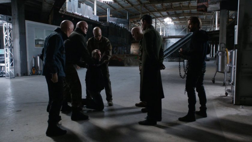 The Inhuman primitives hold down Radcliffe in front of Hive inside abandoned shopping mall.