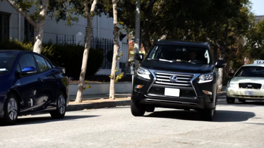 Coulson driving a SHIELD SUV along a city street.
