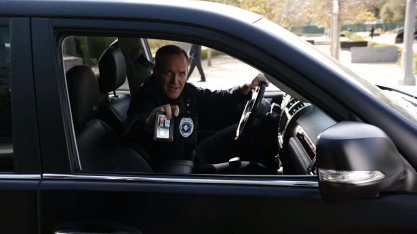 Coulson flashing his badge from within SHIELD SUV.