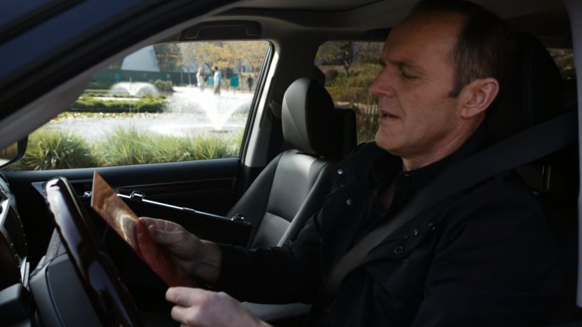 Coulson parked and looking at failsafe codes in SHIELD SUV.