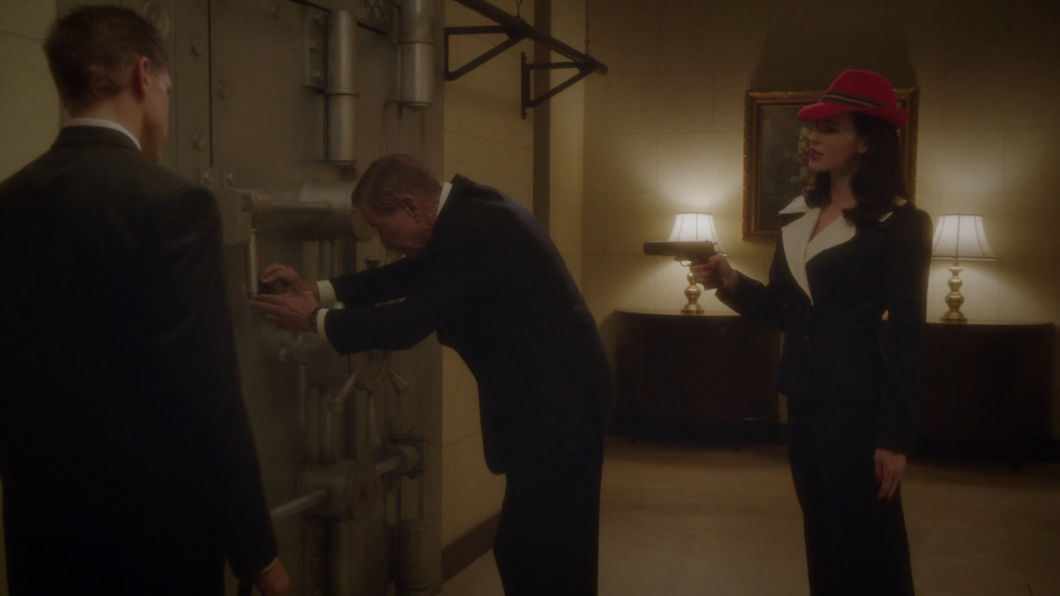 Dottie holding gun on bank manager at Bowery Savings vault.