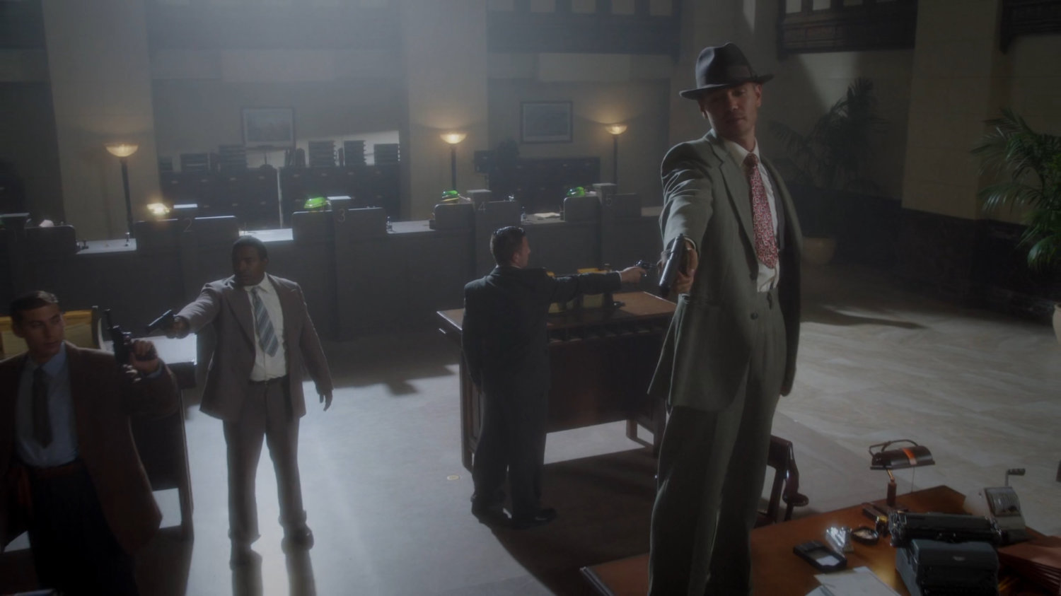 Thompson holding gun while standing on table in Bowery Savings Bank.