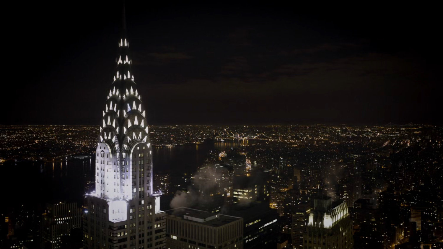 Nighttime aerial of New York City featuring the Chrysler Building.