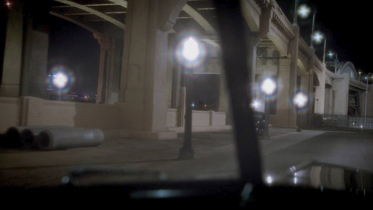 POV from a car pulling up under a bridge.