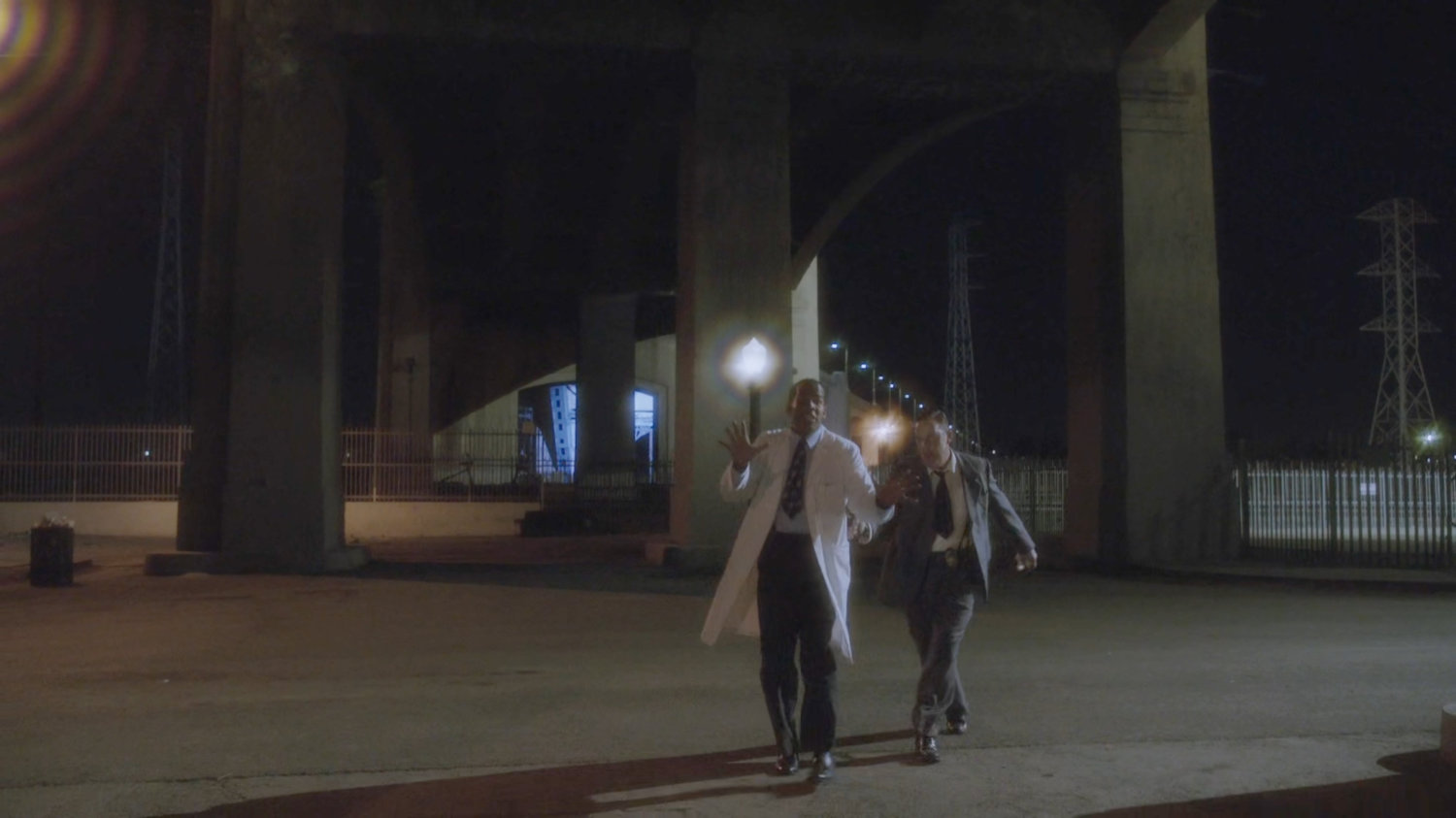 Jason and Detective Henry walking under overpass.
