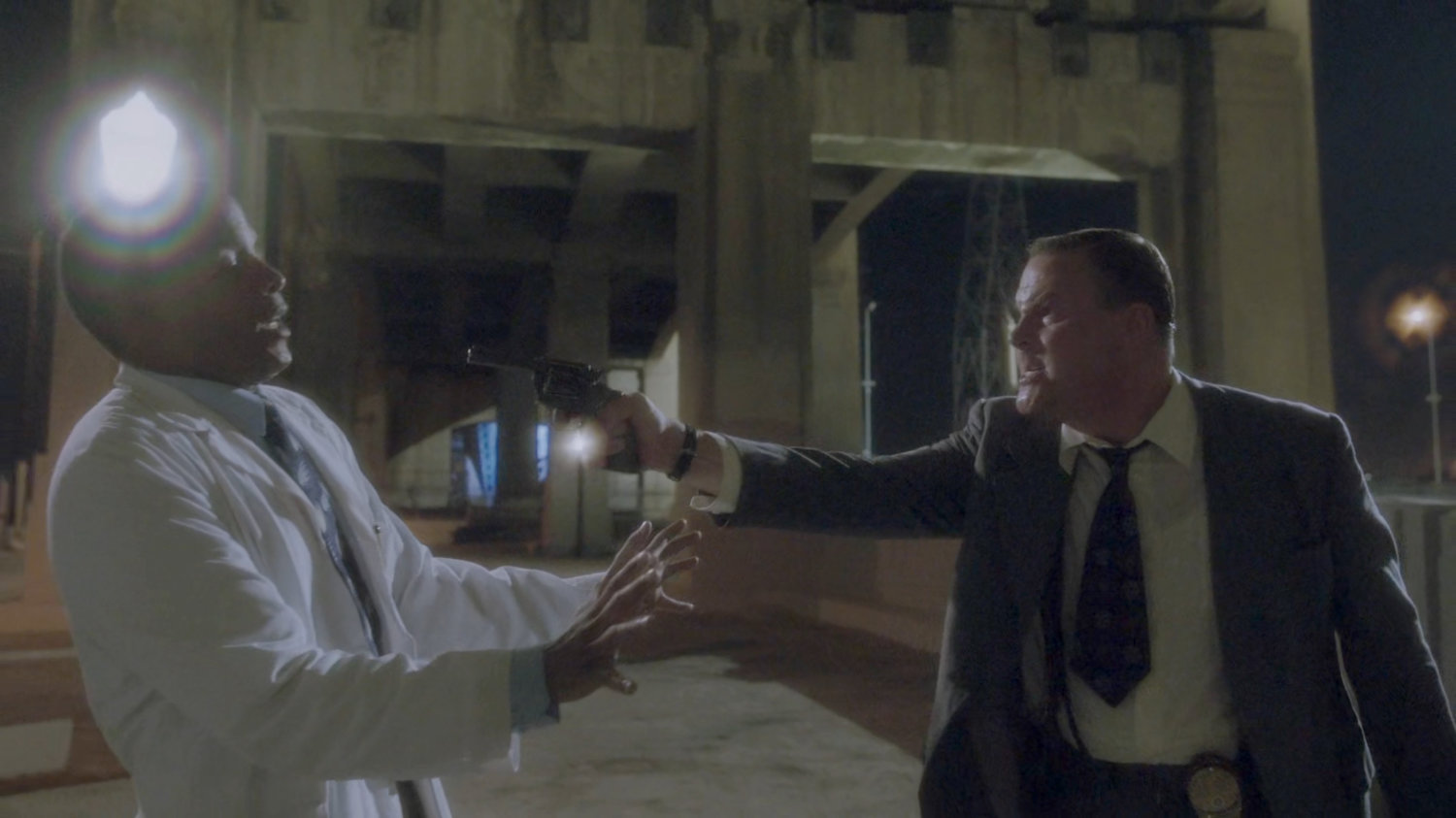 Detective Henry pointing gun at Jason.