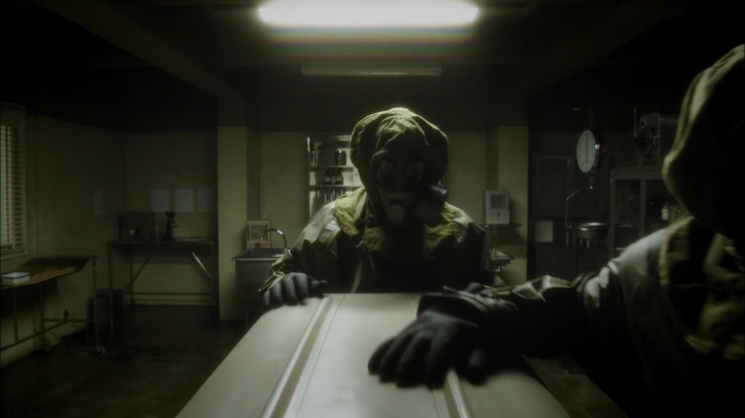 Two SSR agents in hazmat gear remove body from coroner's office.