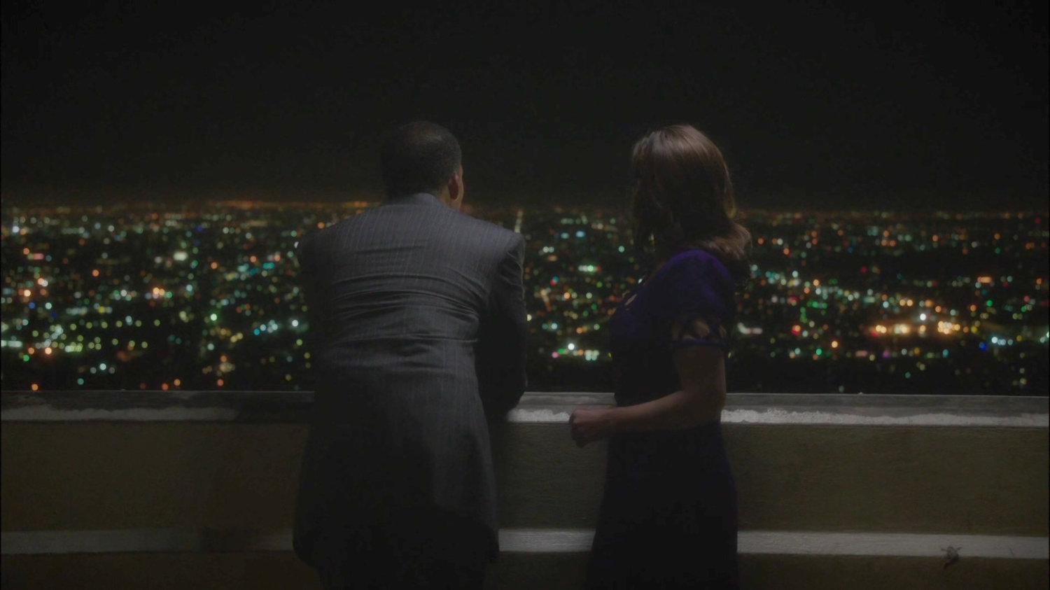 Jason and Peggy look over the light of LA from Griffith Observatory at night.