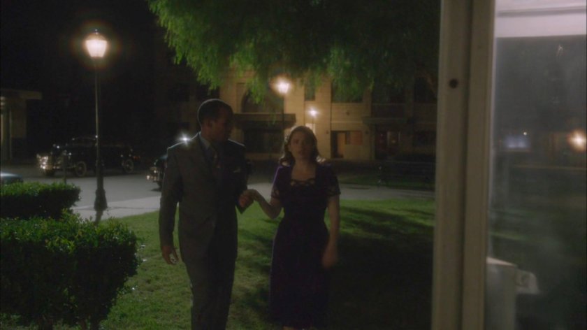Jason and Peggy walk towards phone booth at night.