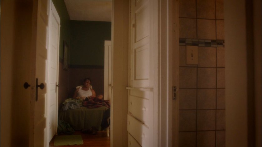 Rufus Hunt on a bed in his house.