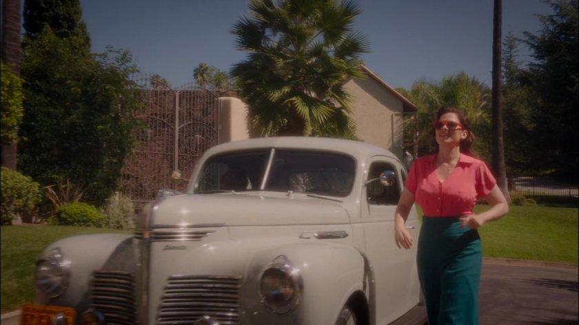 Peggy walking by car to greet Sousa in front of Stark's mansion.