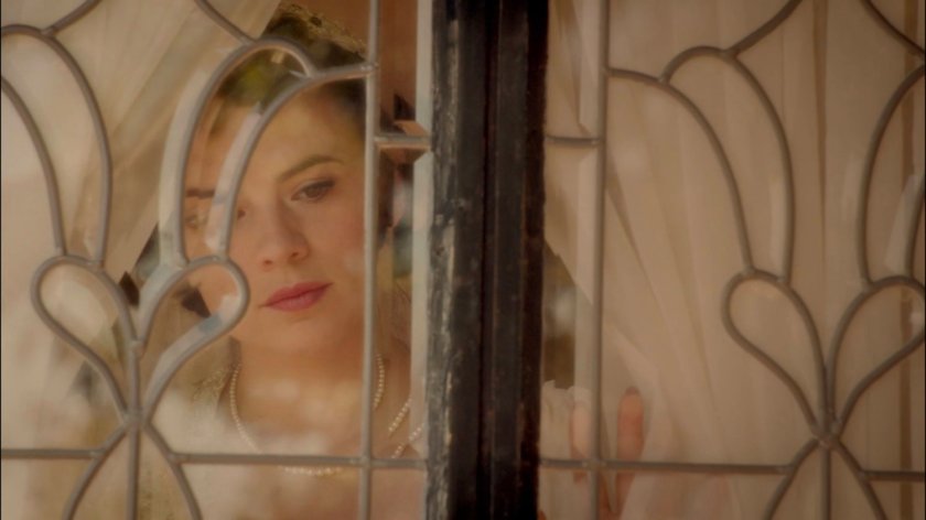 Peggy looking out the window at her house.