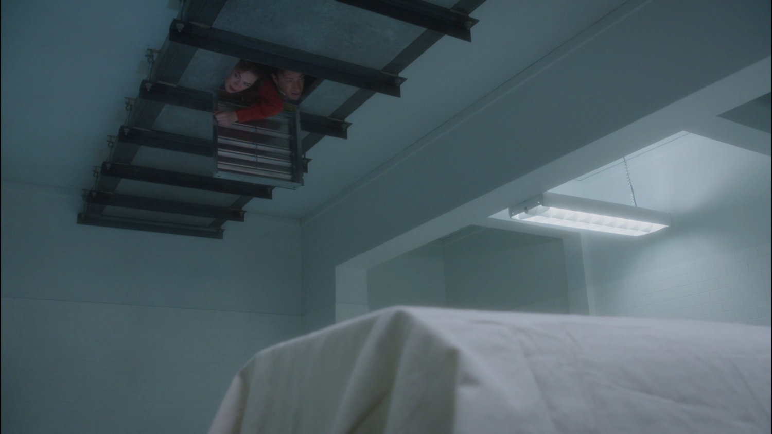 Jarvis and Peggy looking through a vent inside County Cold Storage building.