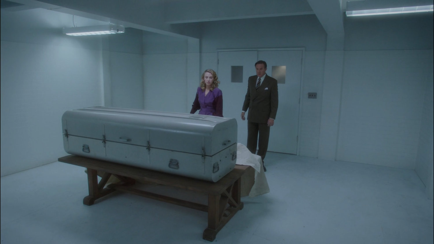 Whitney and Calvin looking at coffin inside County Cold Storage building.
