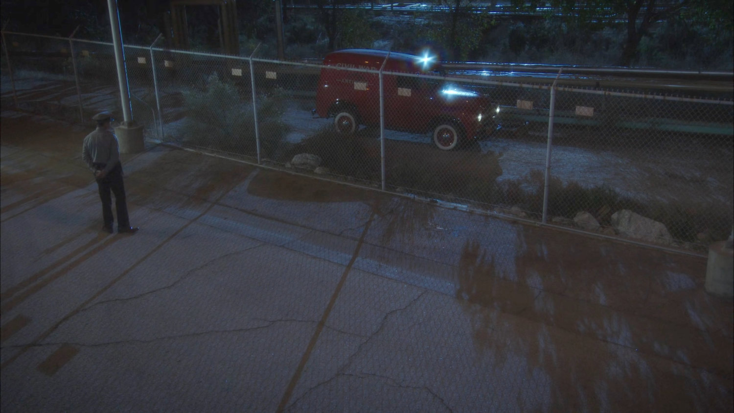 Red Civil War antiques van pulling up outside chain link fence.