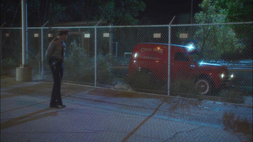 Red Civil War antiques van pulling up outside chain link fence.