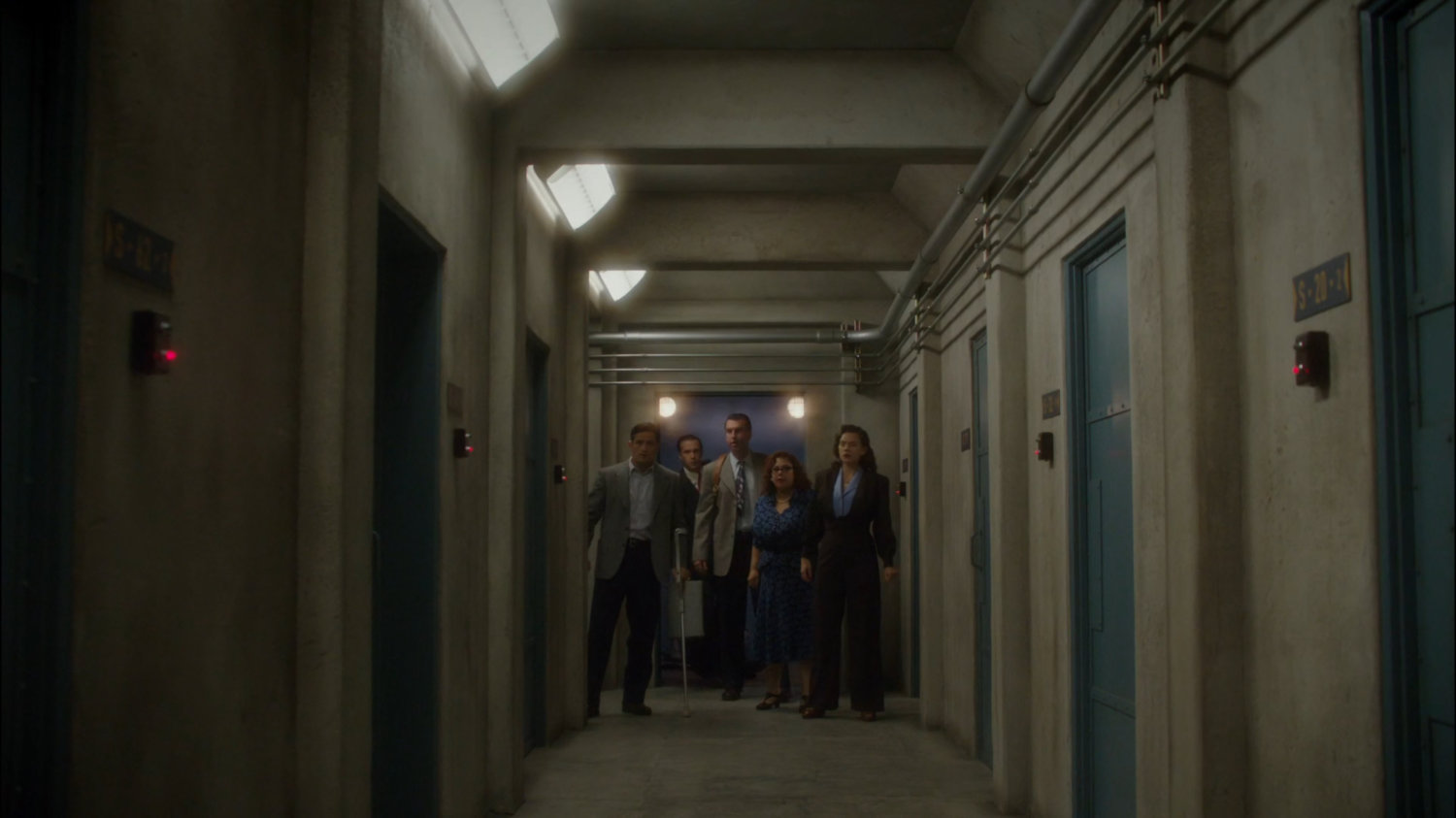 Peggy, Rose, Samberly, Sousa, and Jarvis in vault hallway at Roxxon warehouse.