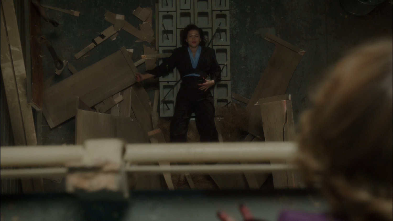 Whitney looking down on Peggy laying on cement blocks with rebar sticking through her side.