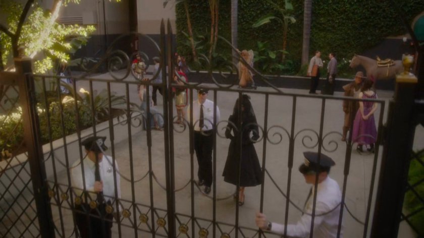 Whitney and guards walking towards front gate of Anvil Studios.