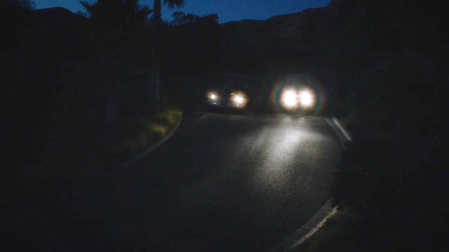 Two cars on dark road at night.