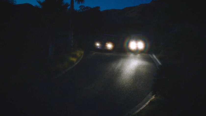 Two cars on dark road at night.