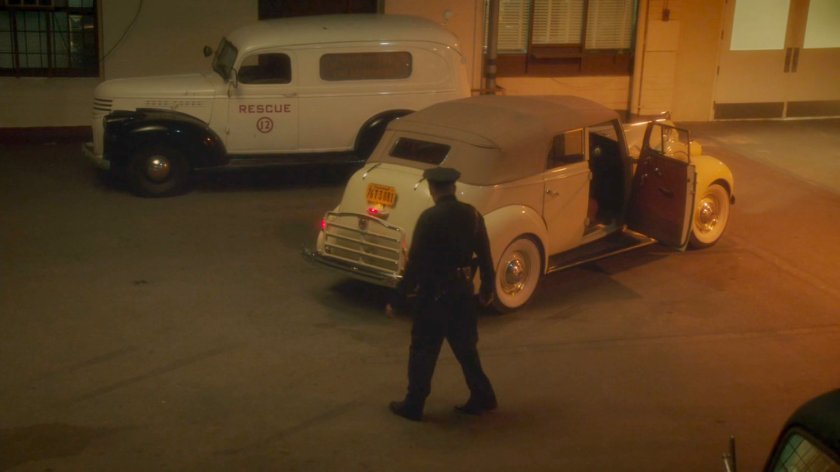 Police officer looking at car outisde Waverly Memorial Hospital at night.