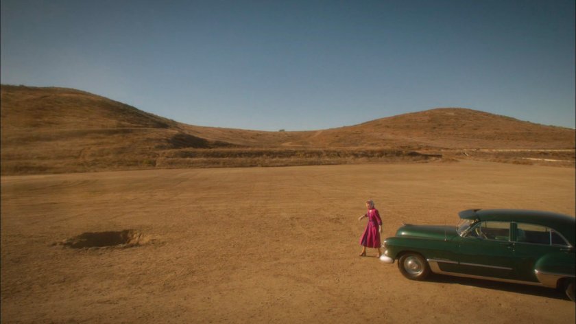 Whitney approaching a crater in the mesa of a Mojave hill.