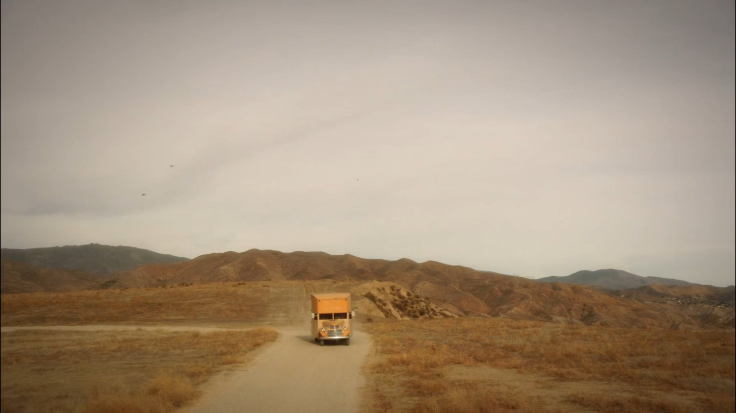 Truck on dusty road in Mojave desert.