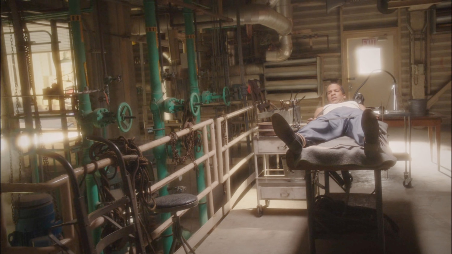 Jason strapped to gurney in Manfredi Waste Management facility.