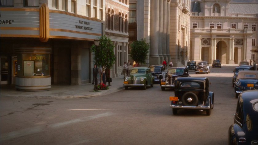 Cars on a street outside theater.