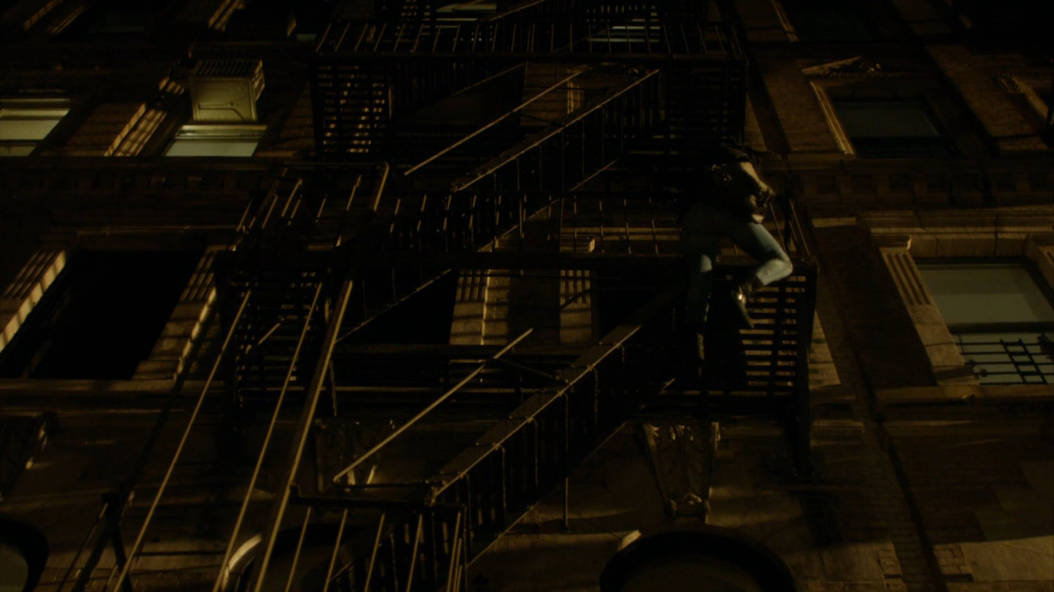 Jessica climbing fire escape across from Luke's bar.